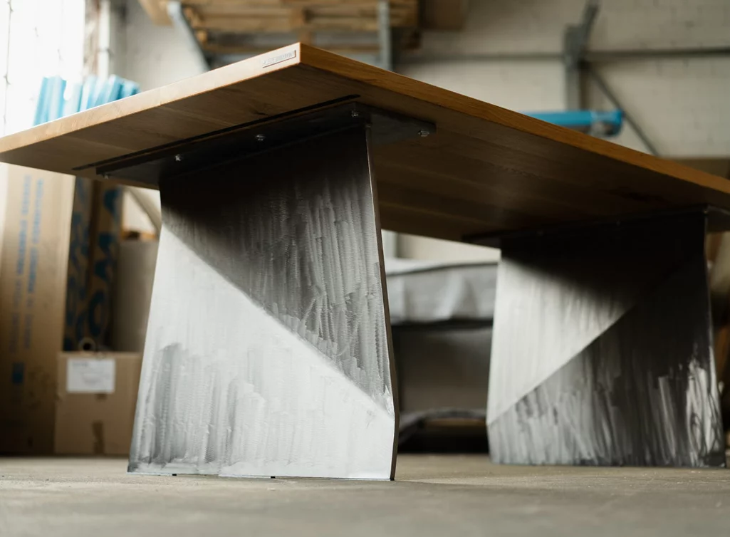 Massiver Holztisch mit Metallwangen Untergestell im futuristischen Design Massiver Holztisch mit Metallwangen Untergestell im futuristischen Design